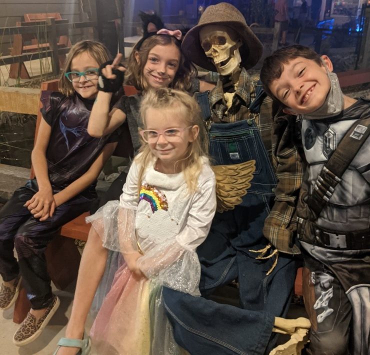Costumed children pose with a skeleton figurine at Frankenville.