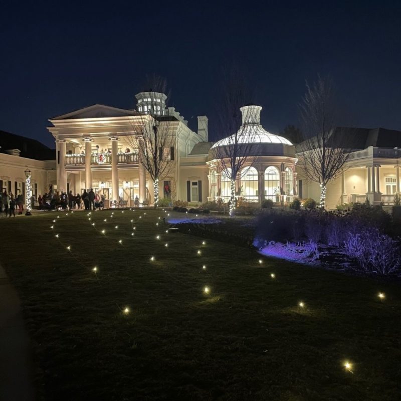 The white buildings at the Huntsville Botanical Garden are illuminated at the end of a lit walkway at the Galaxy fo Lights.
