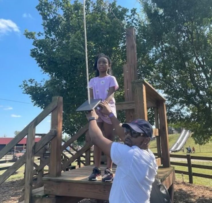 A dad helps his daughter on the zipline at Lyon Family Farm.