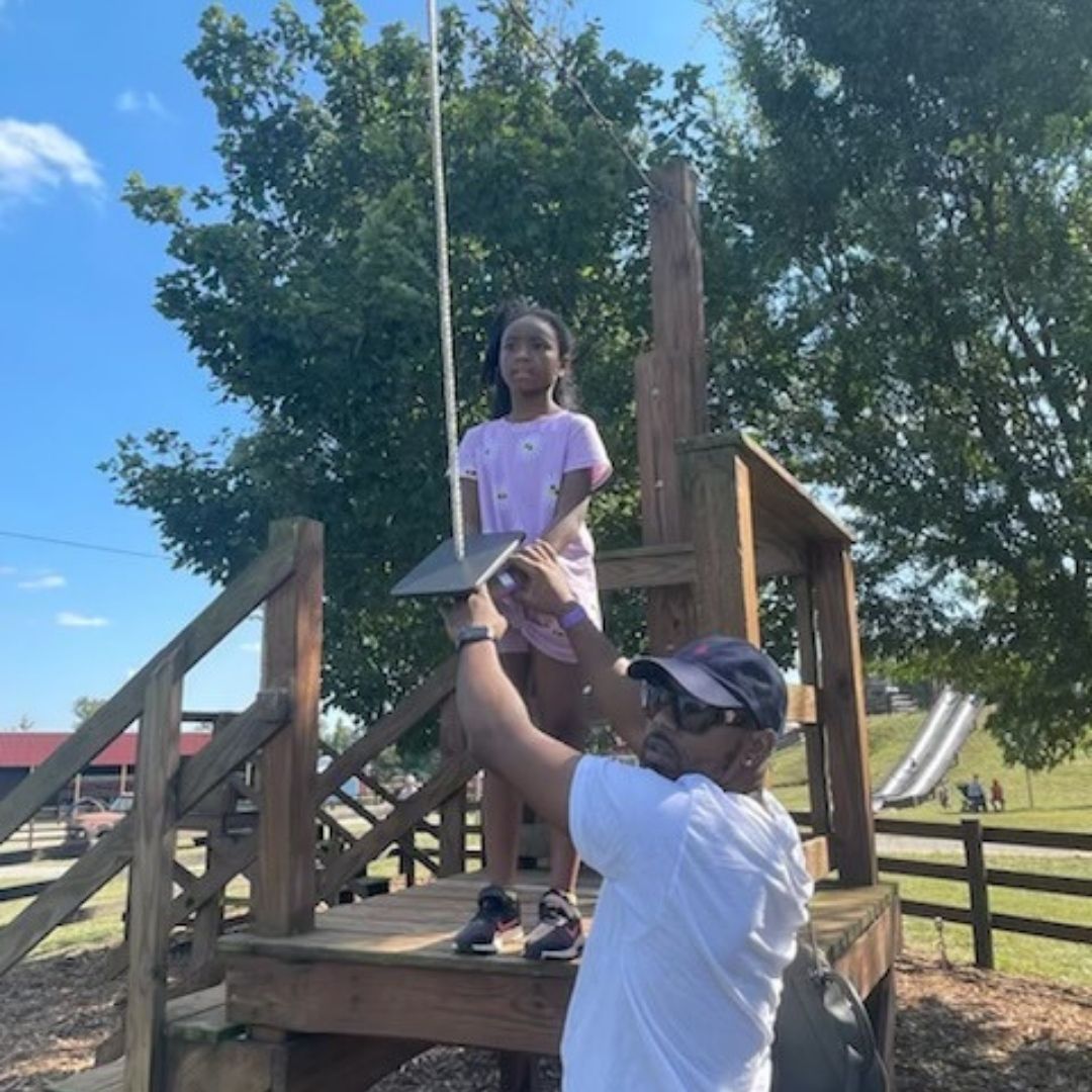 A dad helps his daughter on the zipline at Lyon Family Farm.