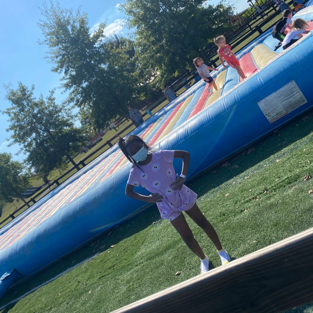 A young girl stands in front of the pillow bounce at Lyon Family Farm.