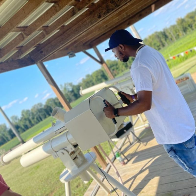 A man shoots apples from the apple canon on the farm.