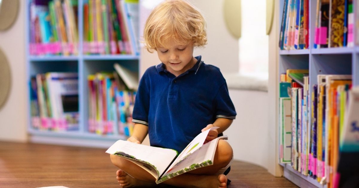 child reading a book inside a library