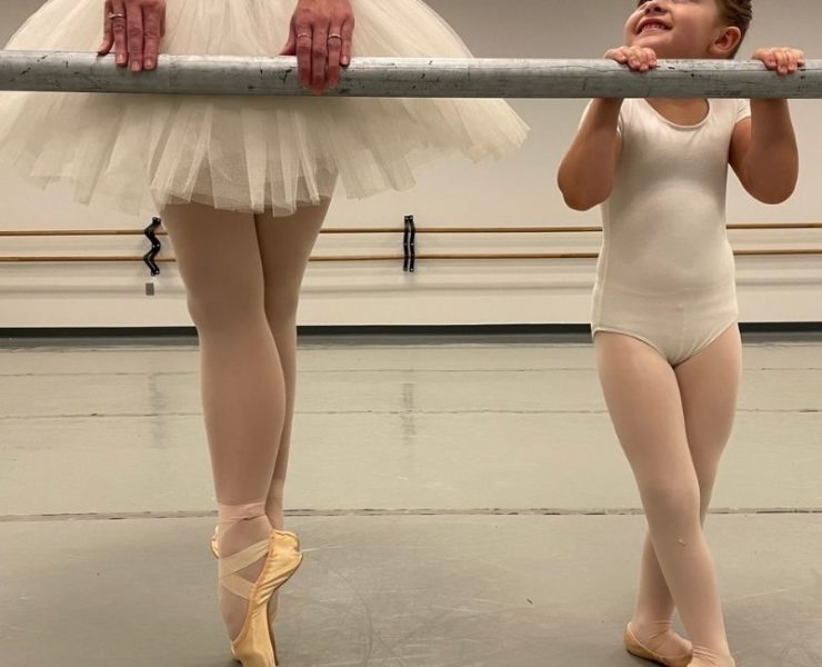 young girl practicint ballet with older teen in a tutu