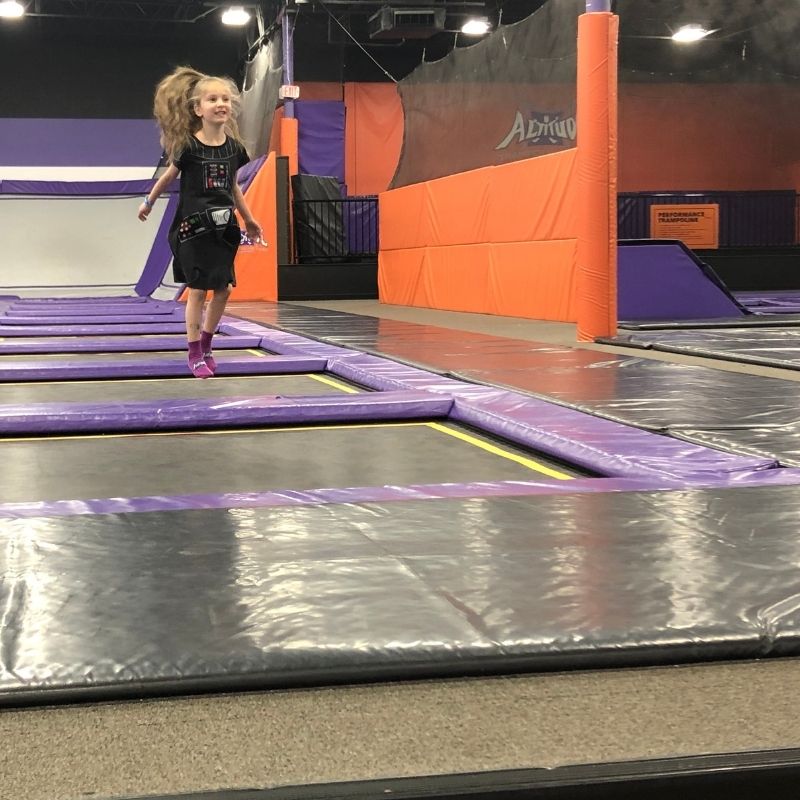 little girl bouncing at an indoor trampoline park