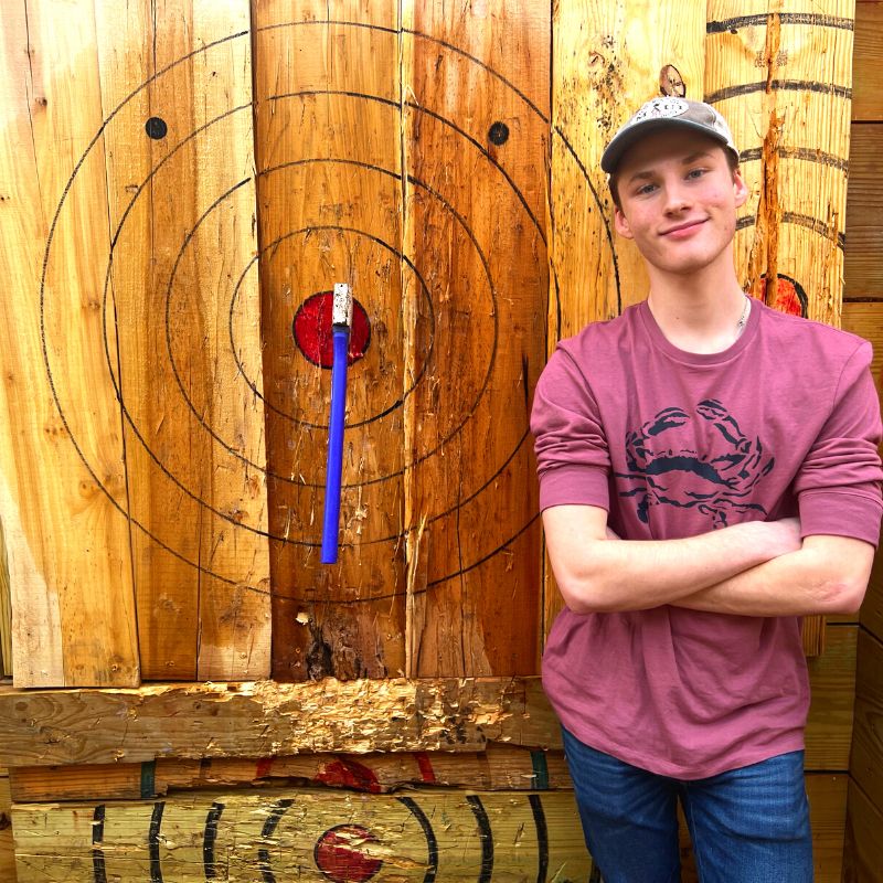 teen at axe throwing range at Ancient Lore Village in Knoxville, TN