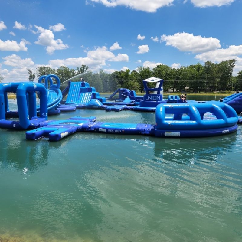 Blue inflatable obstacles float atop the water at the Slippery Summit Aqua Park in Cullman.