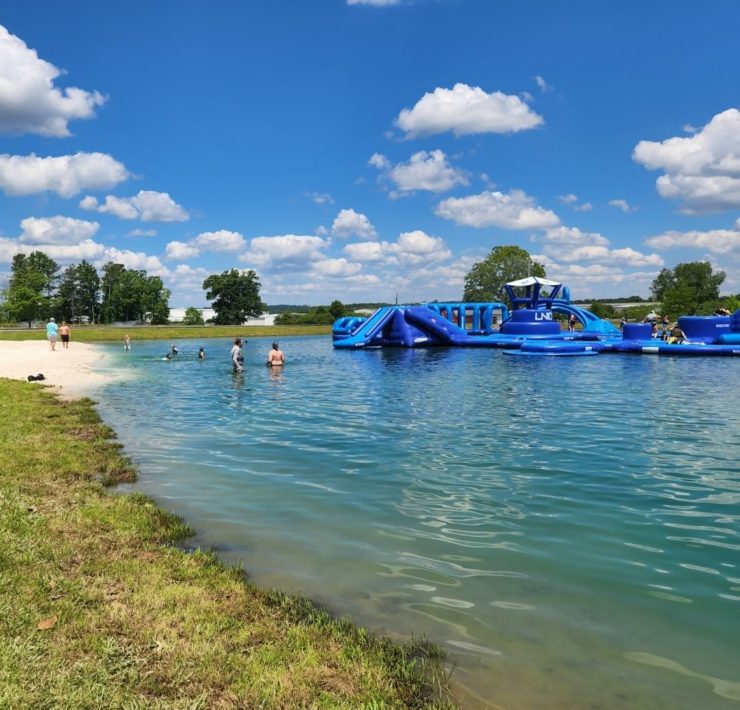 Shallow water laps up to the "beach" on the shores of the Slippery Summit Aqua Park.
