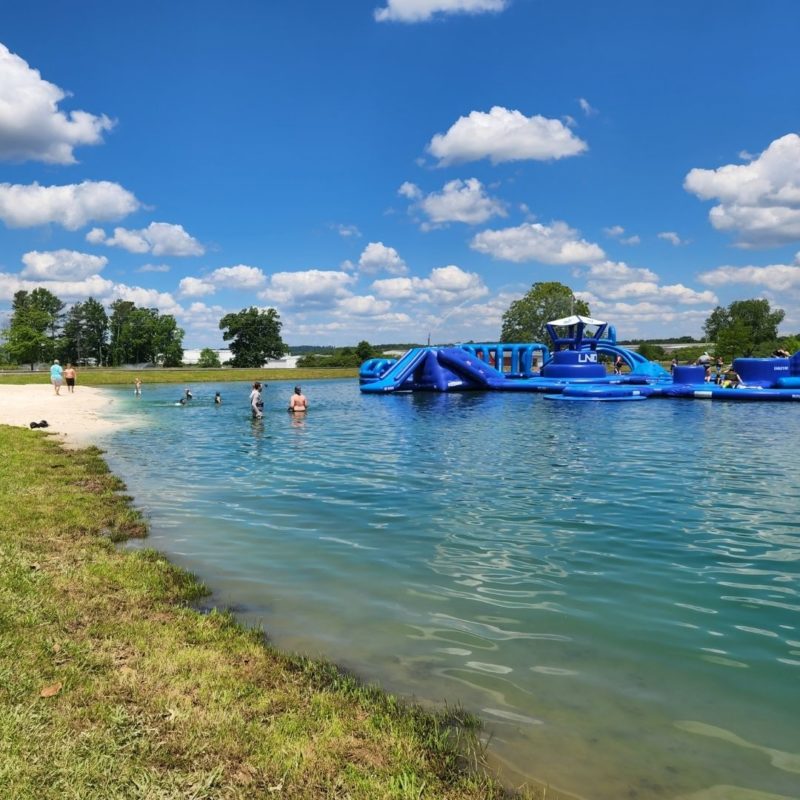 Shallow water laps up to the "beach" on the shores of the Slippery Summit Aqua Park.