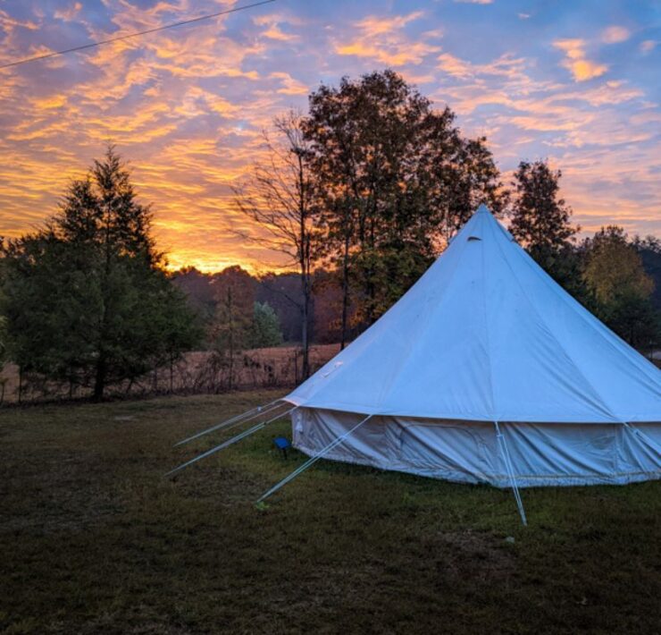 The sun sets behind a white tent in Sipsey Creek.