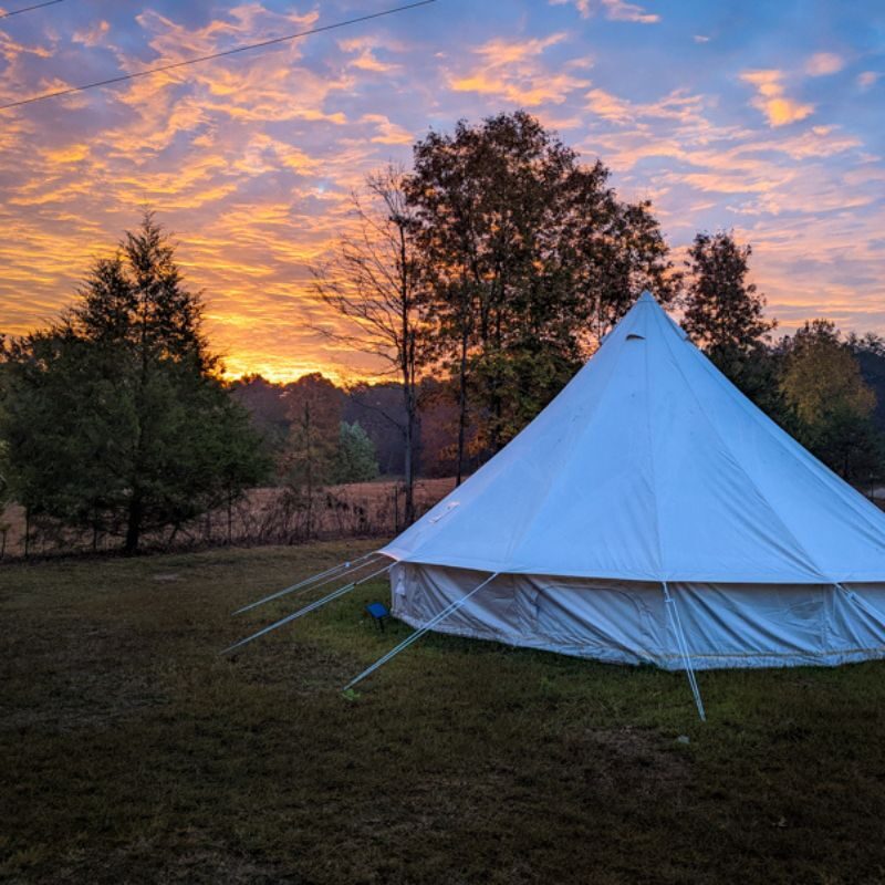 The sun sets behind a white tent in Sipsey Creek.