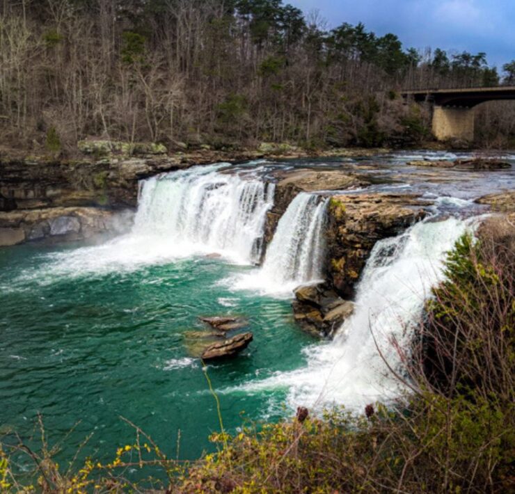 Three large waterfalls pour over into blue-green water at Little River Canyon.