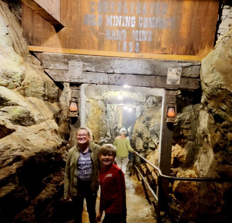 A preteen girl and a younger boy stand at the entrance of the Consolidated Gold Mine in Cleveland, GA.