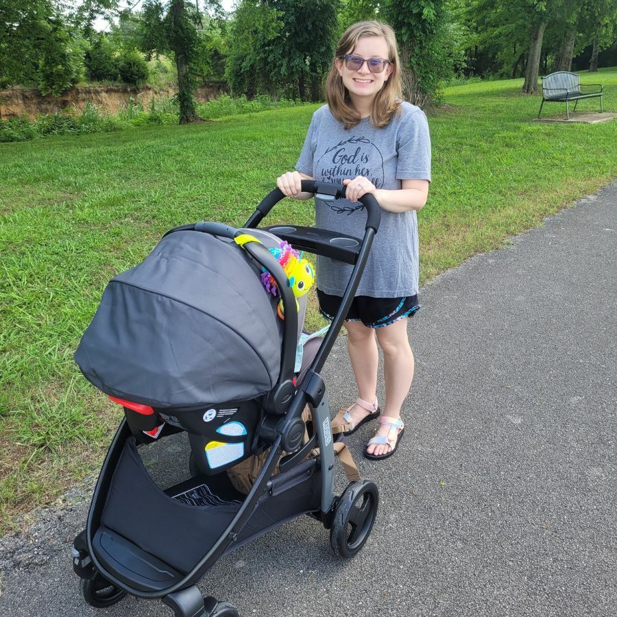 woman wearing glasses pushes baby in a stroller